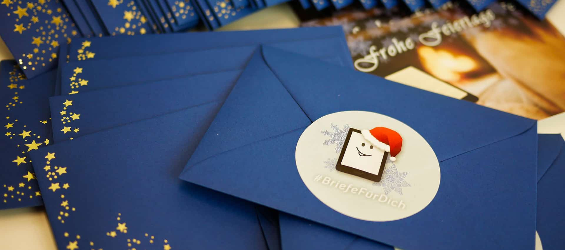 Blaue Briefumschläge mit goldenen Sternen und einem tolino als Sticker